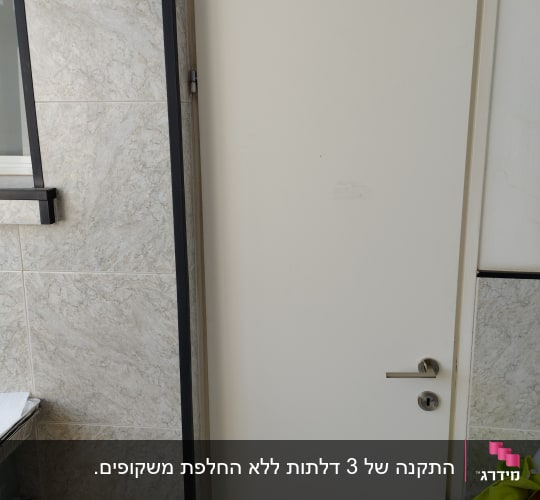 דלת לבנה עם ידית מתכת בחדר פנימי